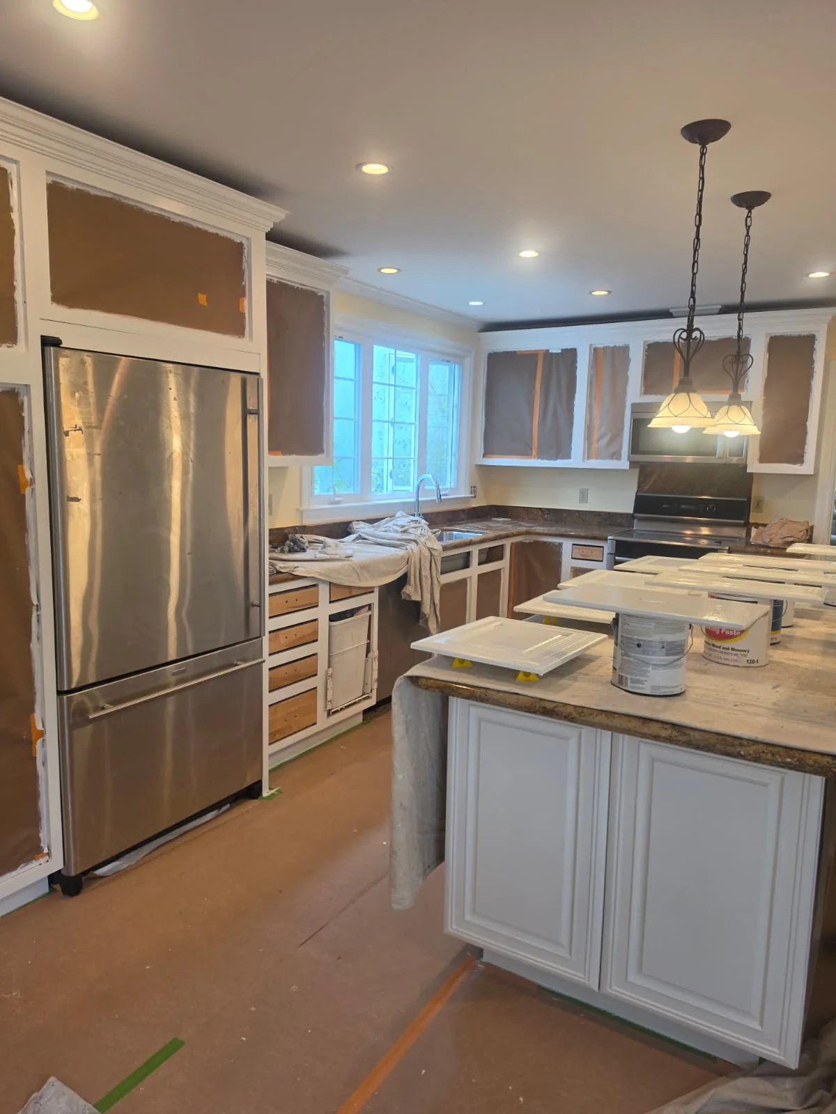 Kitchen cabinet frames being painted, with doors removed
